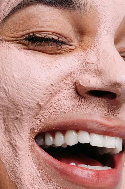 Mulher sorrindo com máscara facial