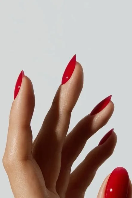 Mãos com unhas vermelhas longas